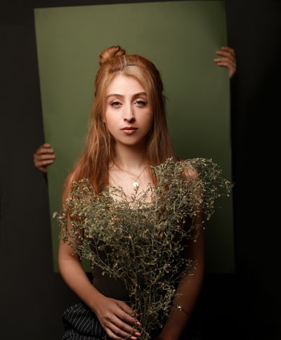 女人拿着枯萎的植物
